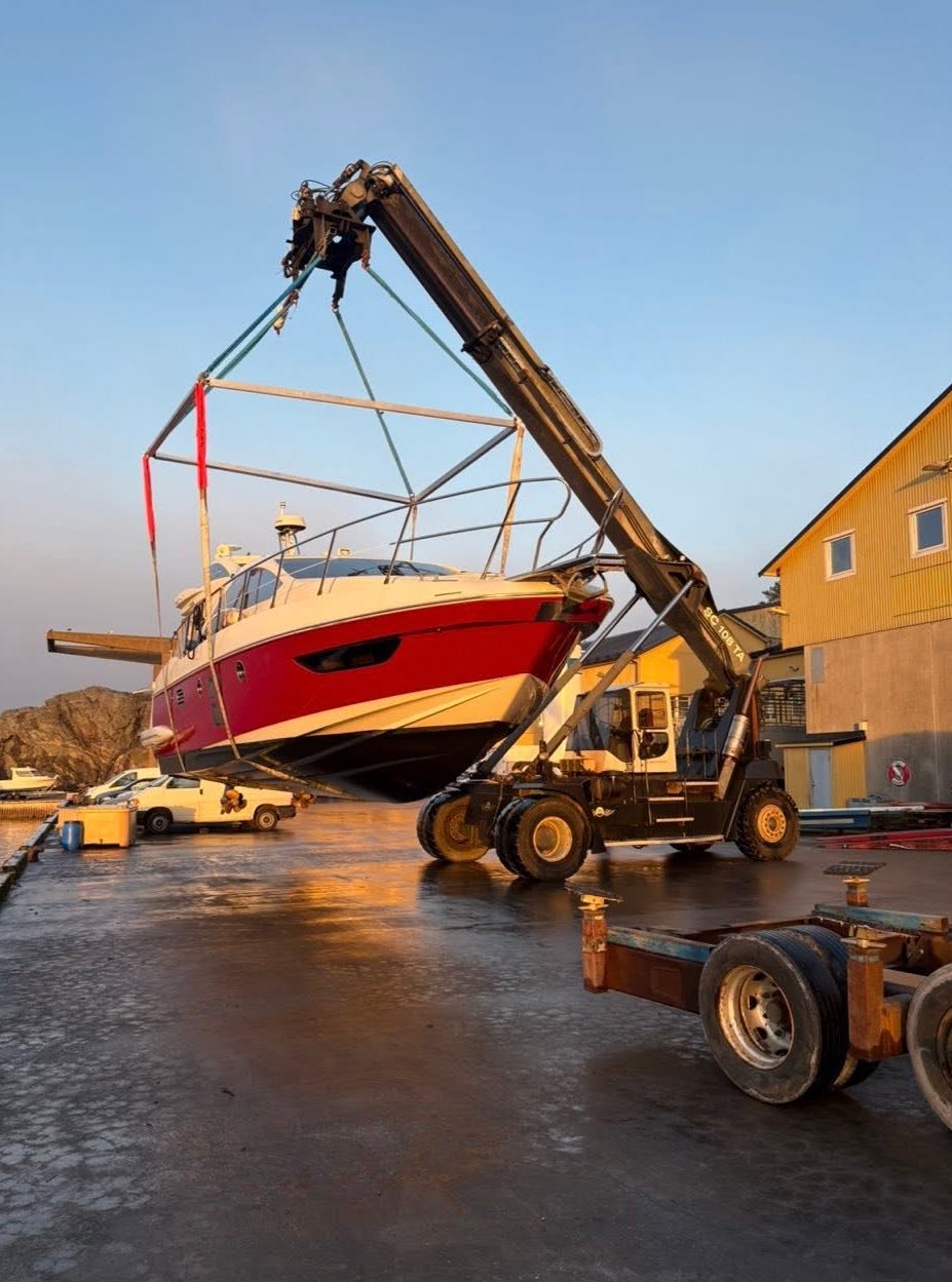 Motorbåt lyfts upp på varvet i kvällsljus